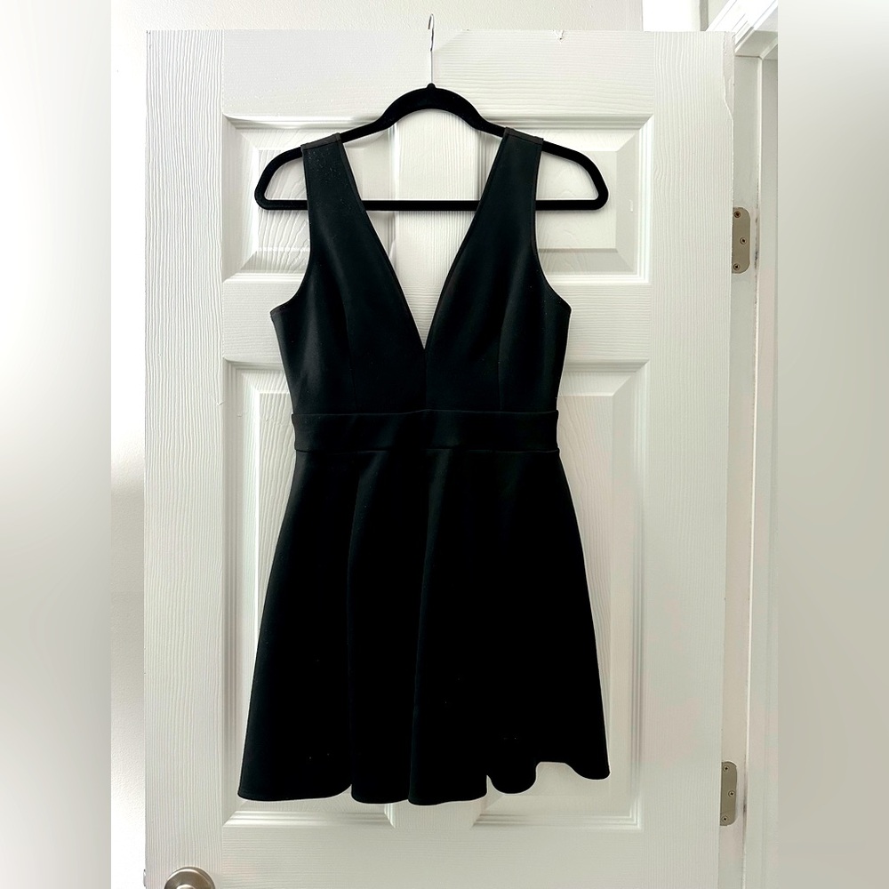 Low cut black V neck. Stretchy flary short skirt.